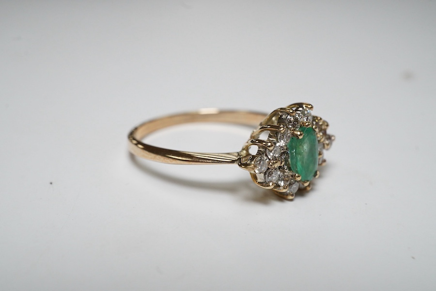 A yellow metal, emerald and diamond cluster set navette shaped ring, size P, gross weight 2.3 grams. Condition - fair to good